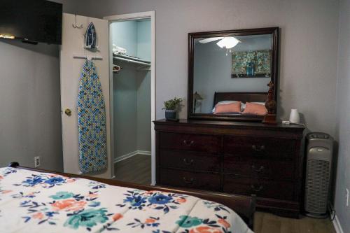 a bedroom with a bed and a dresser and a mirror at Congeniality and Comfort. All the essentials with class, 2 nights? 2 weeks? Stay, relax, work, or go out for fun. in Arlington