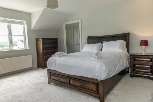 a bedroom with a large bed and a window at Maple Grove, Fahan in Fahan