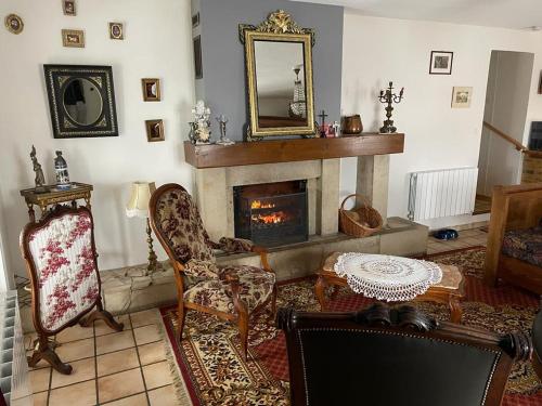 sala de estar con chimenea y espejo en Maison de campagne chaleureuse et au calme, en Léotoing