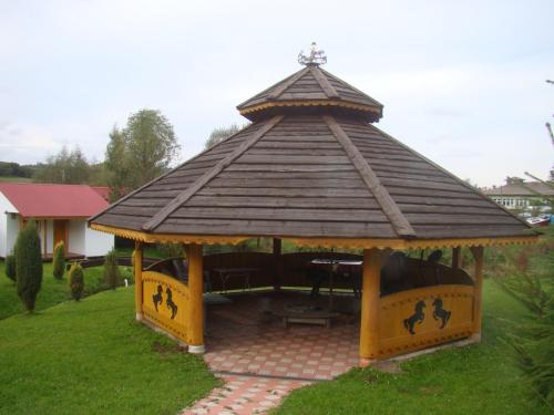 a gazebo with a wooden roof in a yard at Domek Letniskowy 7 in Zawóz