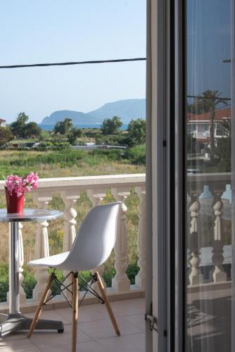 a white chair sitting next to a table on a balcony at Avyssos Residents in Kalamaki