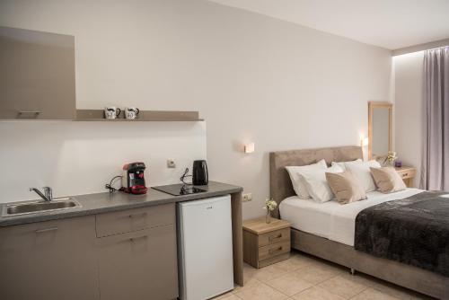 a bedroom with a bed and a kitchen with a sink at Avyssos Residents in Kalamaki