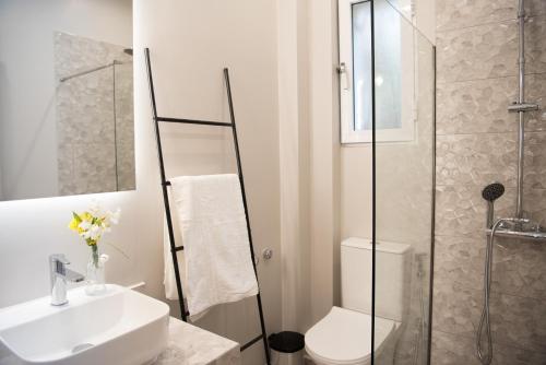 a bathroom with a toilet and a sink and a shower at Avyssos Residents in Kalamaki