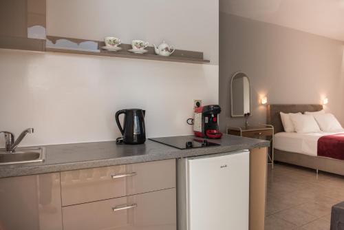 a kitchen with a counter and a bed in a room at Avyssos Residents in Kalamaki