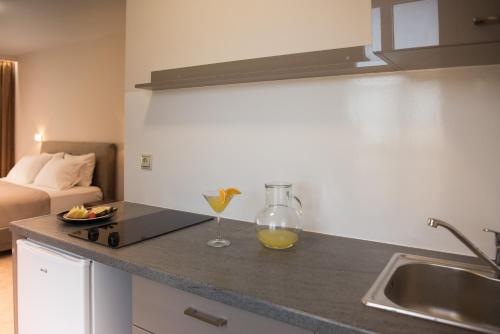 a kitchen with a counter top with a glass of orange juice at Avyssos Residents in Kalamaki