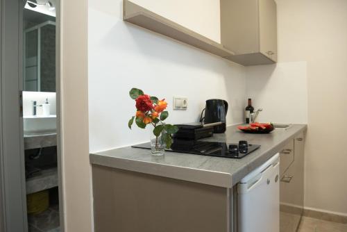 a kitchen with a counter with a vase of flowers at Avyssos Residents in Kalamaki