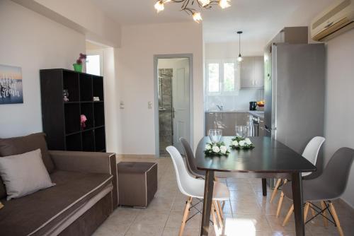 a living room and kitchen with a table and a couch at Avyssos Residents in Kalamaki