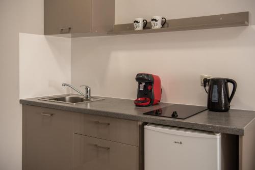 a kitchen with a sink and a red appliance on a counter at Avyssos Residents in Kalamaki