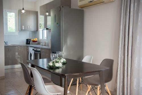 a kitchen with a dining room table and chairs at Avyssos Residents in Kalamaki