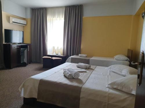 a hotel room with two beds and a television at Casa Mario in Eforie Nord