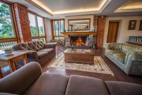 a living room with couches and a fireplace at Farina Park Hotel in Bento Gonçalves