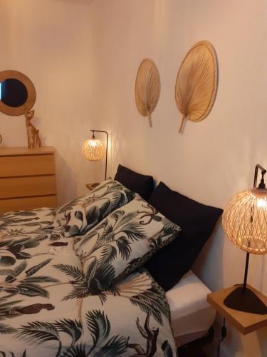 une chambre avec un lit et deux miroirs au mur dans l'établissement L' atelier du 26, à Dinan