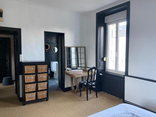 a bedroom with a desk and a table and a window at CHAMBRE SPACIEUSE DANS MAISON RENOVEE in Granville