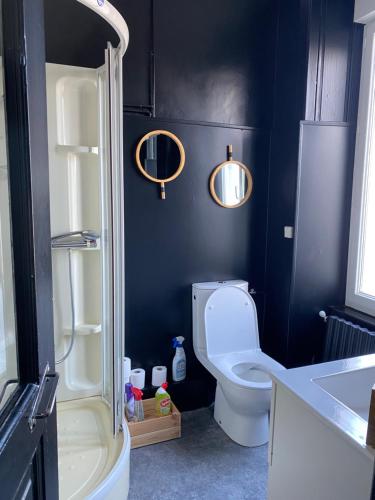 a bathroom with a toilet and two lights on the wall at CHAMBRE SPACIEUSE DANS MAISON RENOVEE in Granville