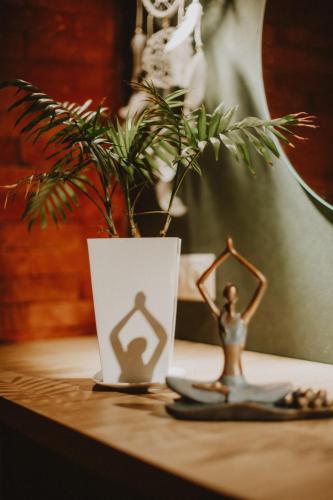 a figurine on a table with a plant and a vase at Luxury Duplex Suites - City Center in Tbilisi City