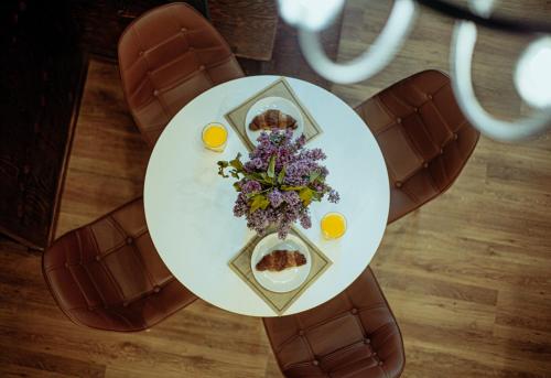 a table with a plate of food and flowers on it at Luxury Duplex Suites - City Center in Tbilisi City