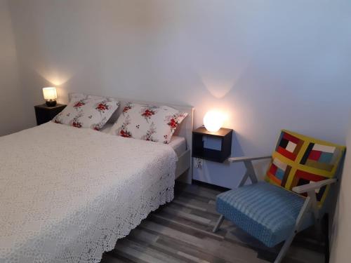 a bedroom with a bed and a chair and lights at Apartman Burte, Komiža in Komiža