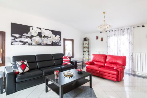 a living room with a red couch and a red chair at Casa delle Noci country house, pool & SPA in Modena