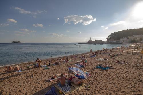 a group of people laying on a beach at Apartments Lidija in Petrovac na Moru