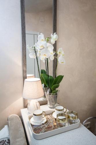 a tray with a vase of flowers on a table at Apartments Lidija in Petrovac na Moru