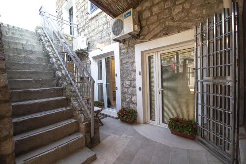 a stone house with stairs leading to a door at Apartments Lidija in Petrovac na Moru