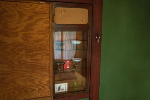 a wooden cabinet with two cups in it at Machiya Guest House Carta in Kanazawa