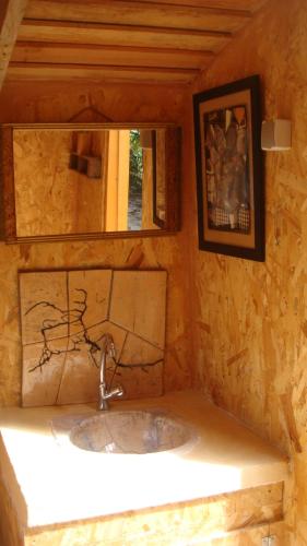 uma casa de banho com um lavatório e um espelho em Kerterre des Gallerands em Bessais-le-Fromental