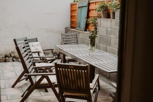 a table with chairs and a vase of flowers on a patio at Modernisiertes Fachwerkhaus in Rheinbach bei Bonn in Rheinbach