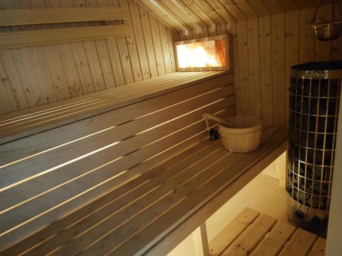 a wooden sauna with a window and a bucket at Mazury całoroczny dom do wynajęcia nad jeziorem in Pasym