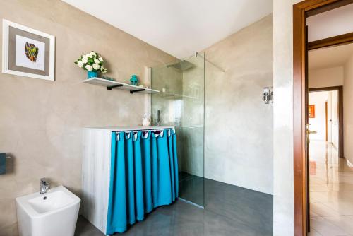 a bathroom with a shower curtain and a toilet at Casa delle Noci country house, pool & SPA in Modena