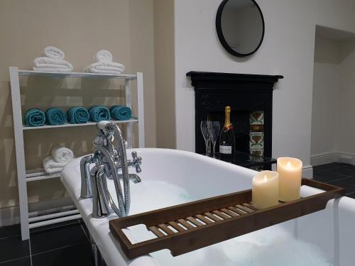 a bath tub with two candles and a fireplace at Coastal escape in the heart of Saltburn in Saltburn-by-the-Sea