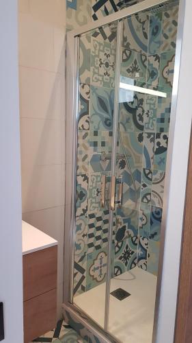 um chuveiro com uma porta de vidro na casa de banho em Appartement bord de mer em Dinard