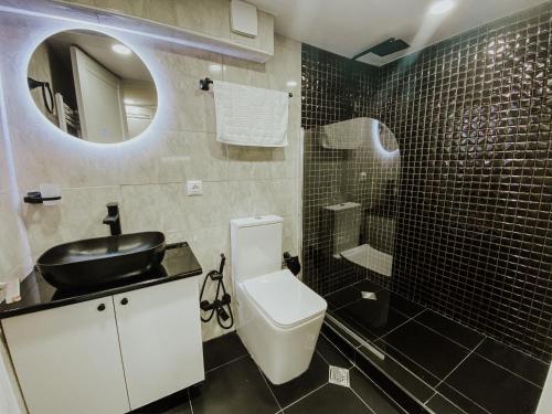 a bathroom with a toilet and a sink and a mirror at Luxury Duplex Suites - City Center in Tbilisi City