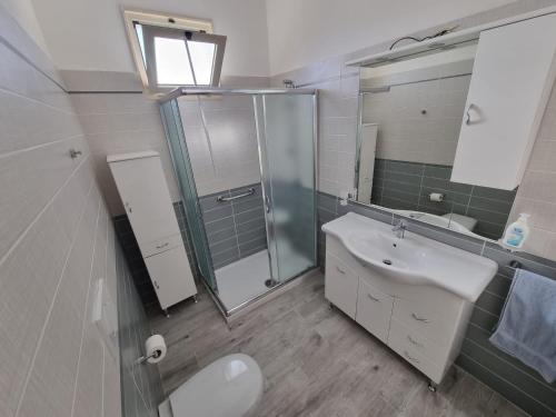 a bathroom with a sink and a shower and a toilet at Villetta Azzurra in Torre Lapillo