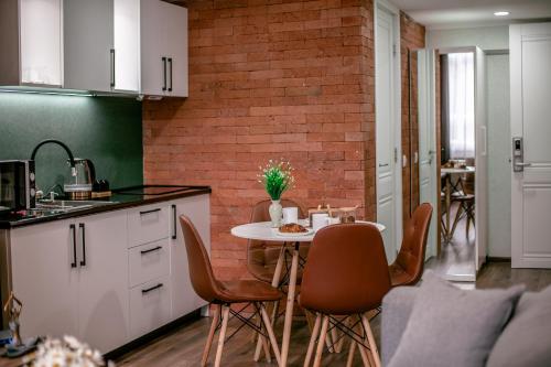 a kitchen with a table and chairs and a brick wall at Luxury Duplex Suites - City Center in Tbilisi City