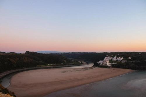 an aerial view of a beach at sunset at Sudoeste Guest House in Odeceixe