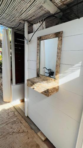 a mirror on the side of a white wall at Casa Can Pep Tauet in San Ferrán de ses Roques