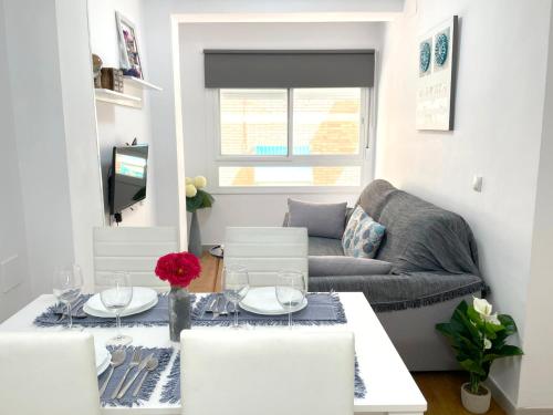 ein Wohnzimmer mit einem Tisch und einem Sofa in der Unterkunft Apartamento Vialia in Málaga