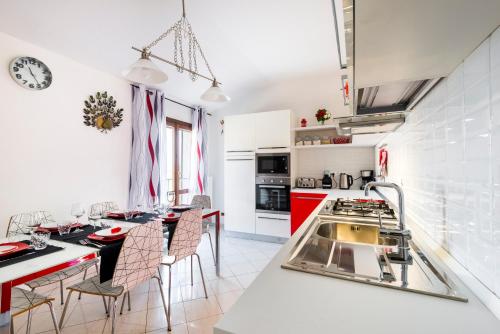 a kitchen with a dining table and a kitchen with red at Casa delle Noci country house, pool & SPA in Modena