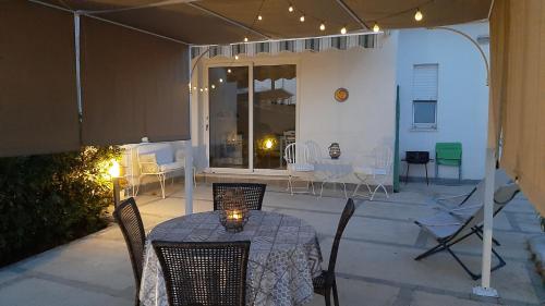 a patio with a table and chairs and a room with at Casa Mare Ognina in Ognina
