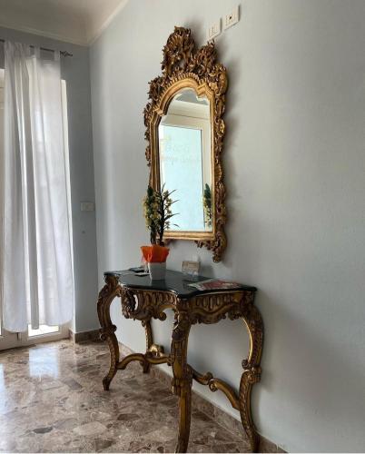 a mirror on a wall next to a table at B&B Vacanze Salento in Torre San Giovanni Ugento