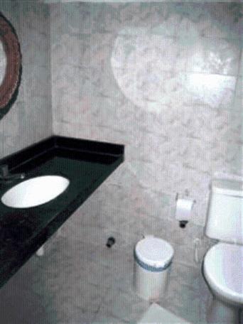 a bathroom with a white toilet and a sink at Pousada Vira Sol in Trairi