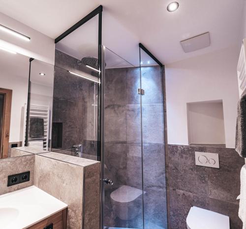 a bathroom with a glass shower stall and a sink at ARLhome - Zuhause am Arlberg in Sankt Anton am Arlberg