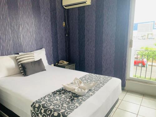a bedroom with a bed with a flower on it at Hotel & Suites Bausan in Boca del Río
