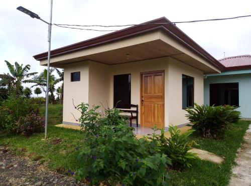 a small house with a wooden door at Cabinas El Pilón Río Celeste in San Rafael