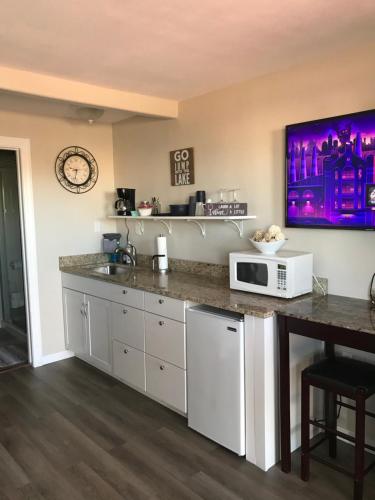 a kitchen with a counter with a microwave and a table at Red Rock Motel and Dam Motel in Page