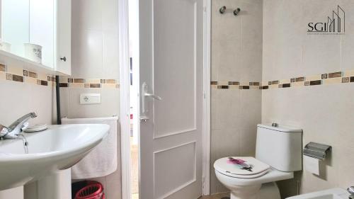 La salle de bains est pourvue de toilettes blanches et d'un lavabo. dans l'établissement Magnífico y acogedor apartamento- WIFI- A 5 MINUTOS DE LA PLAYA, à Finestrat