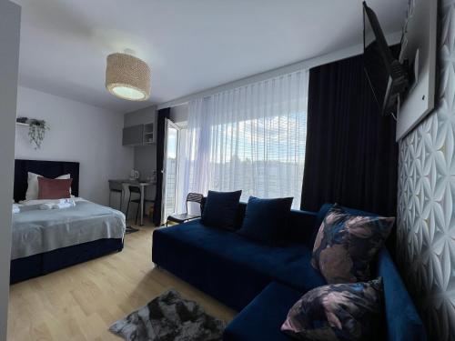 コウォブジェクにあるS&M Villa Kolobrzegのリビングルーム(青いソファ、ベッド付)