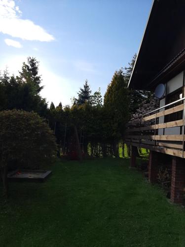 a yard next to a house with green grass at Dom Przy Lesie in Wisła