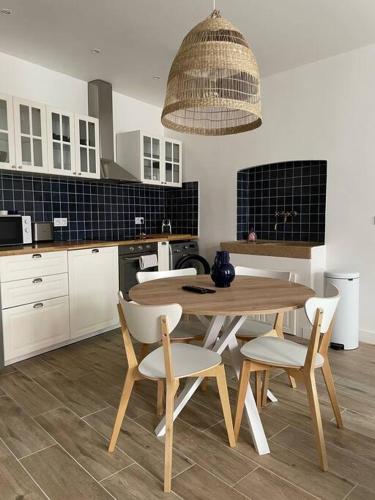 eine Küche mit einem Holztisch und weißen Stühlen in der Unterkunft Cassis centre, superbe appartement neuf, 50m port. in Cassis